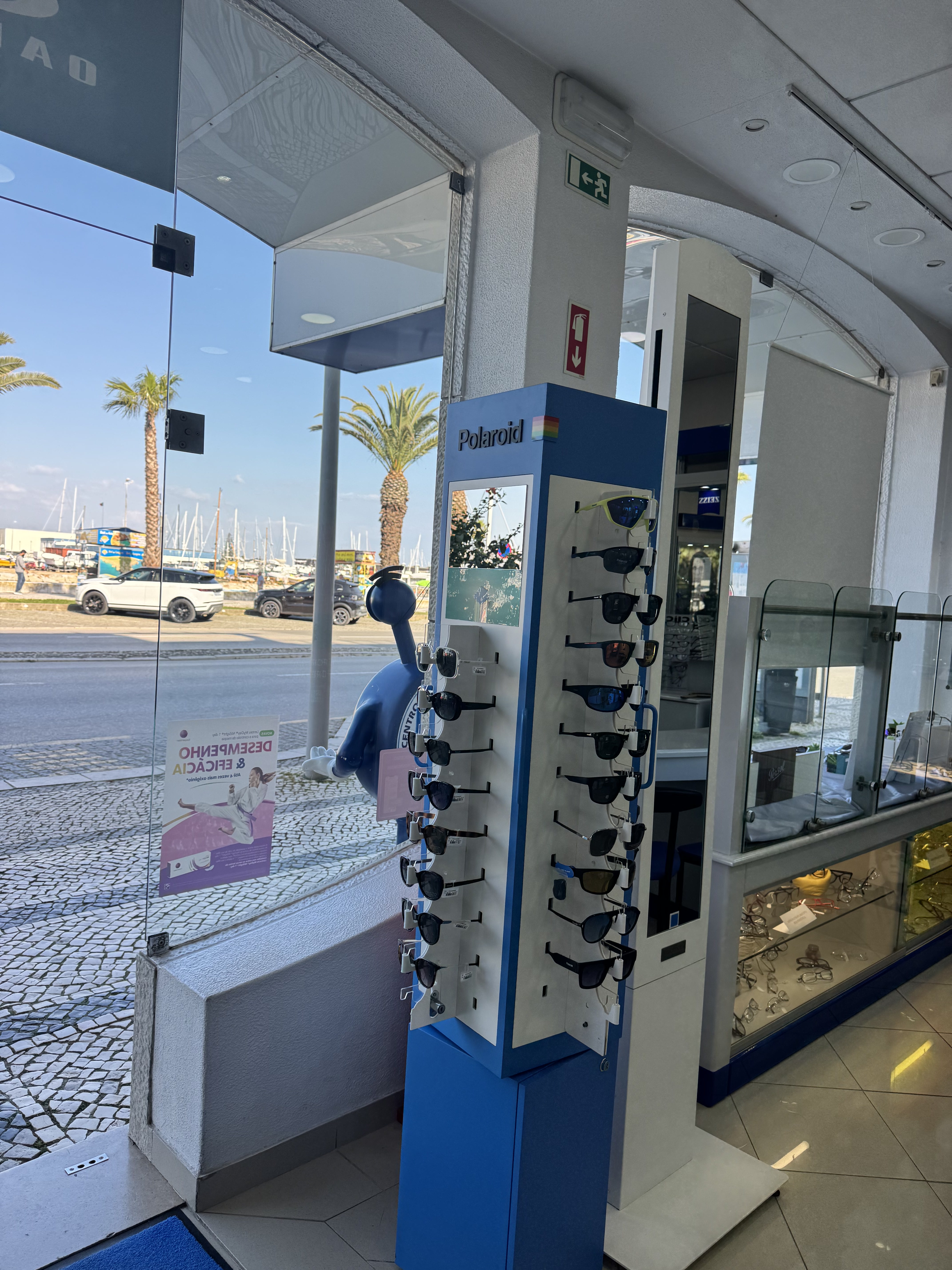 Vista da loja Centro Óptico De Lagos com marina e palmeiras ao fundo